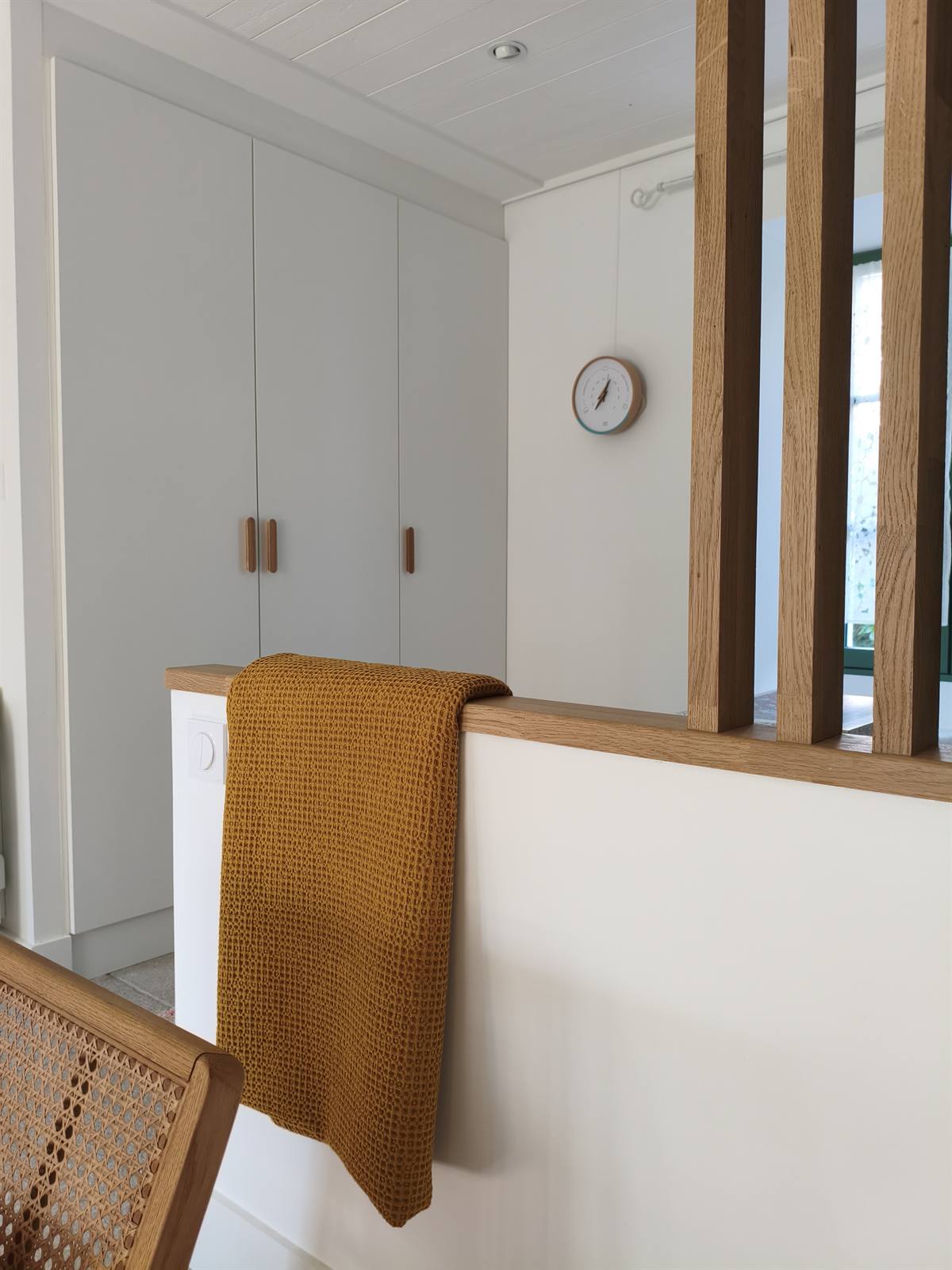 Placards blancs sur mesure et plaid moutarde posé sur le muret du claustra