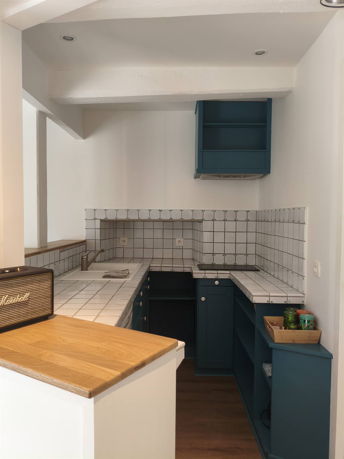 Kitchenette repeinte en bleu canard, plan de travail en bois et carrelage blanc