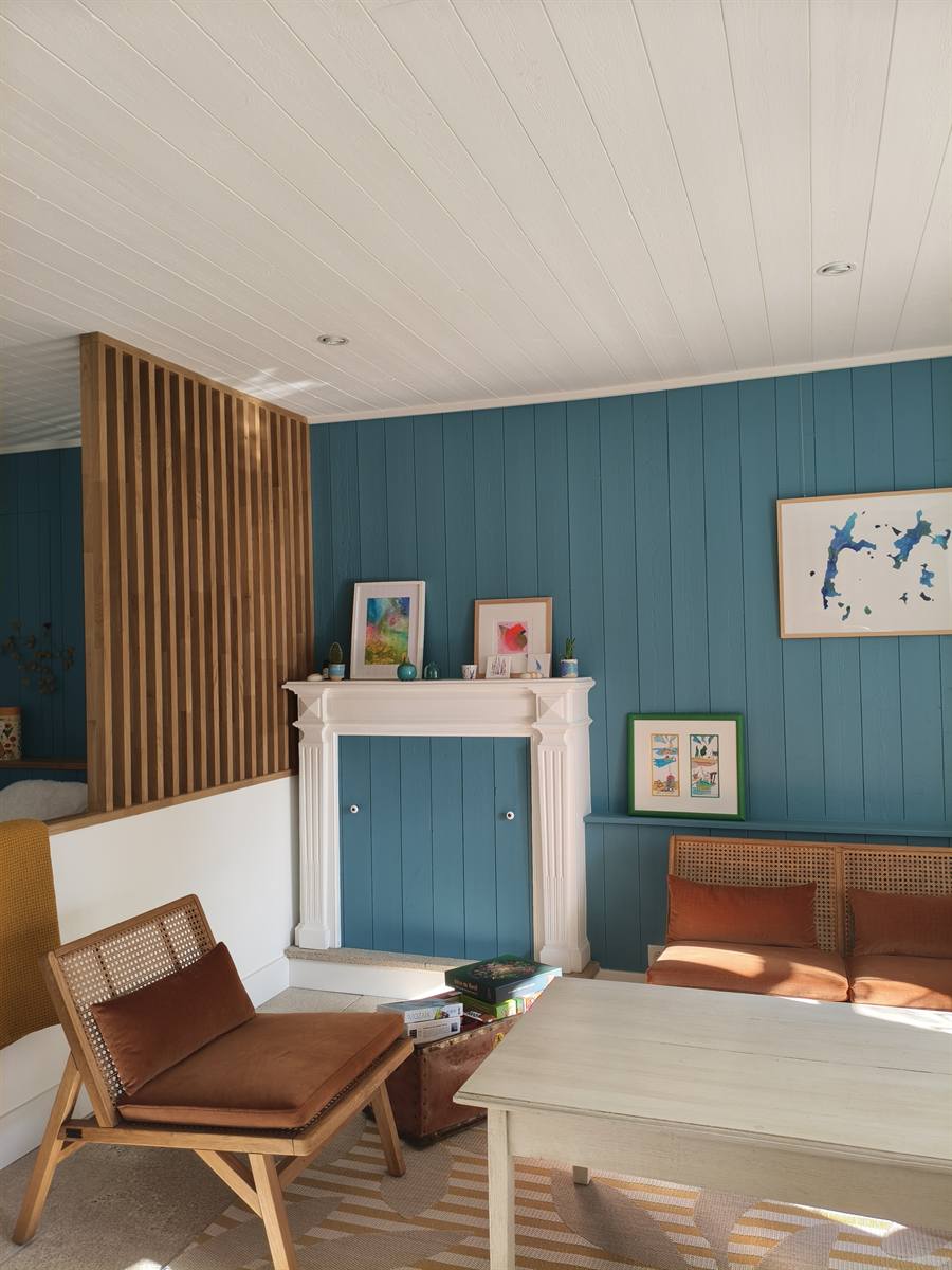 Après : lambris bleu canard, claustra en chêne et coin salon devant la cheminée