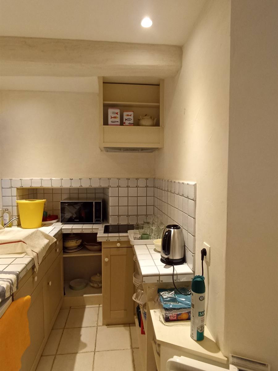 Avant : kitchenette aux meubles beiges et au carrelage clair