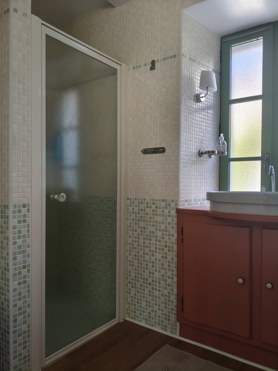Après : meuble vasque rouge brique et douche à porte vitrée