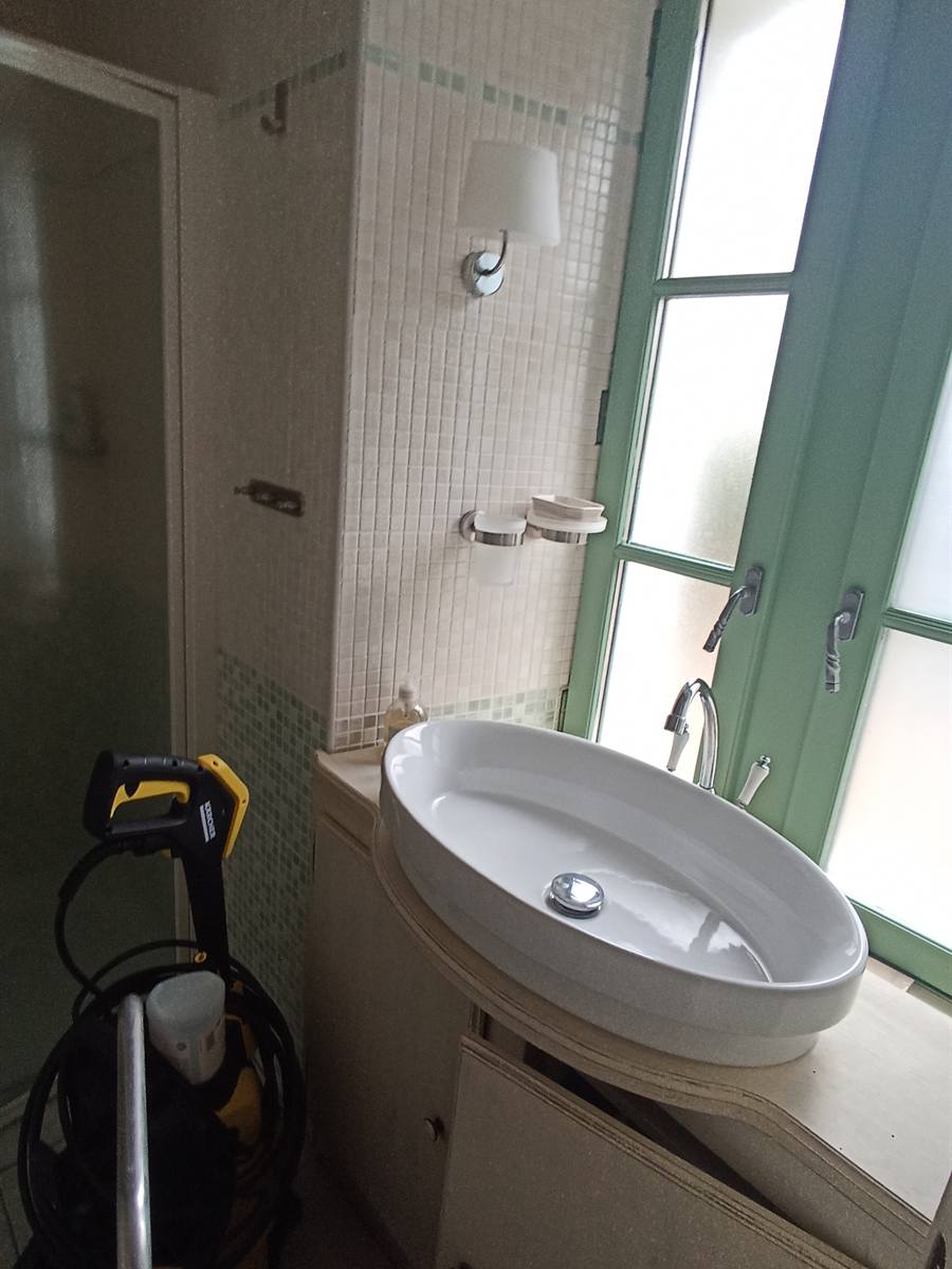 Avant : salle d'eau avec vasque ovale sur un meuble blanc abîmé