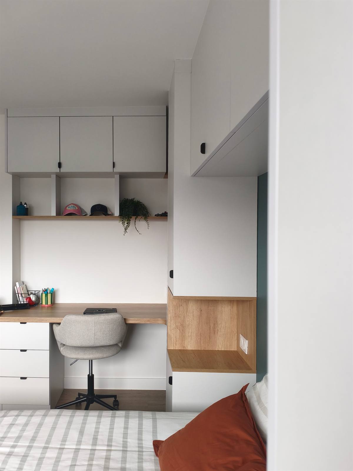 L'espace bureau entre deux colonnes de rangement, chaise pivotante et plan en chêne