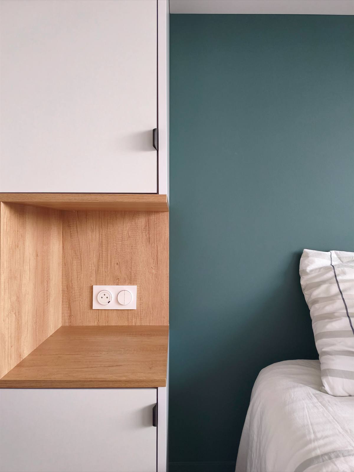 Détail de la niche en chêne entre le placard blanc et le mur vert sapin