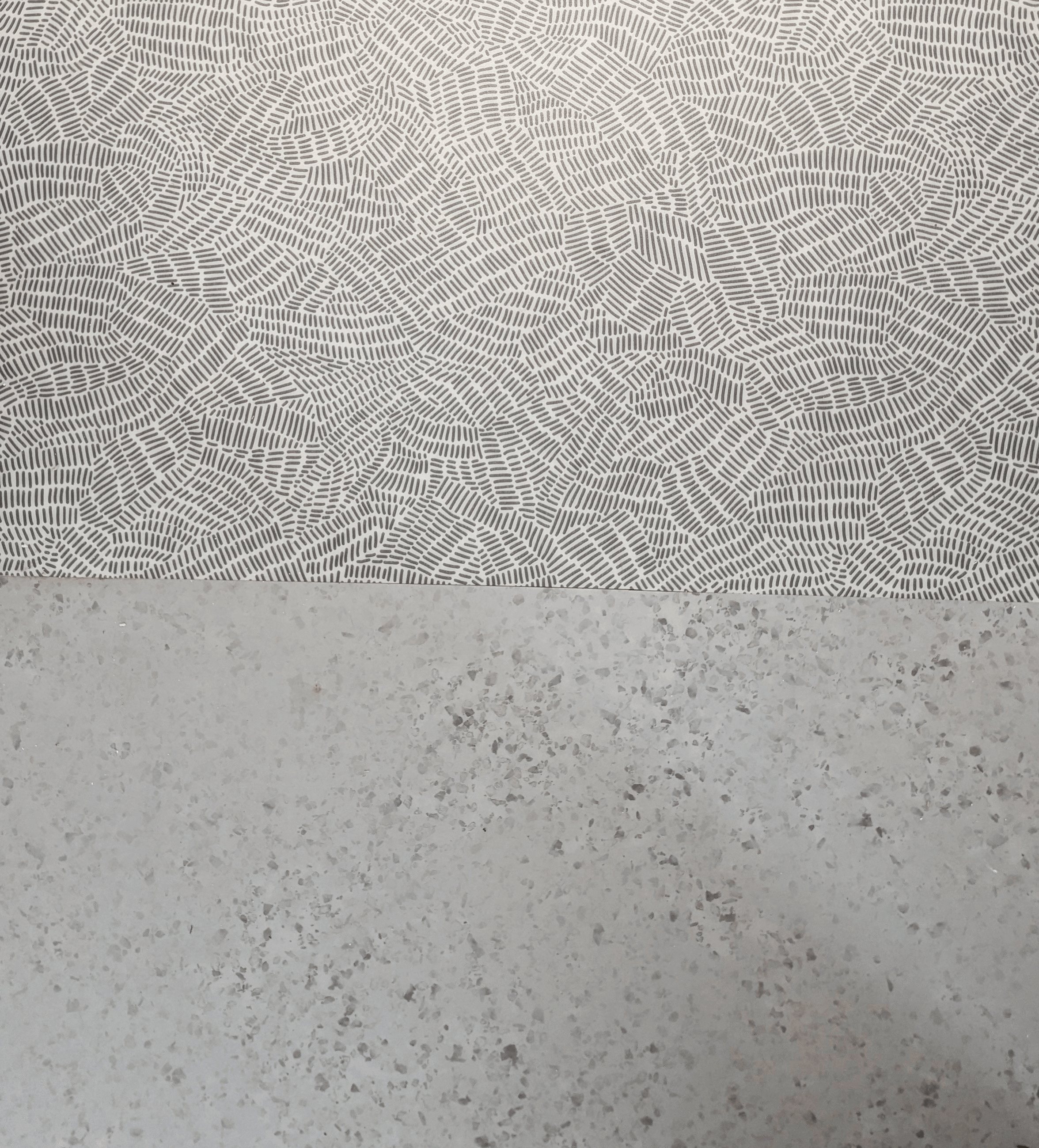 Jonction entre le sol souple à motif graphique et le sol clair des sanitaires