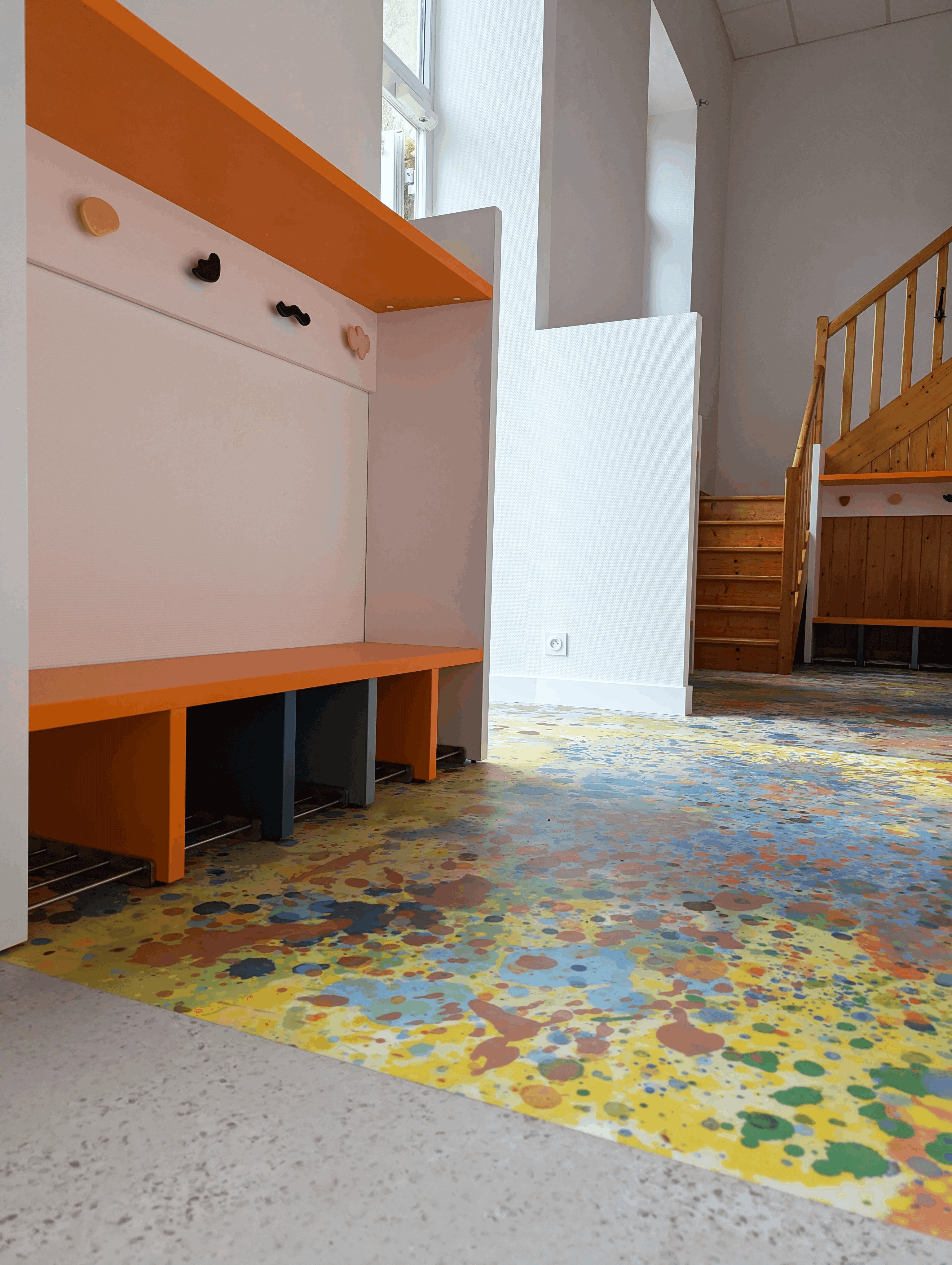 Vestiaire aménagé au pied de l'escalier en bois existant, conservé dans la rénovation