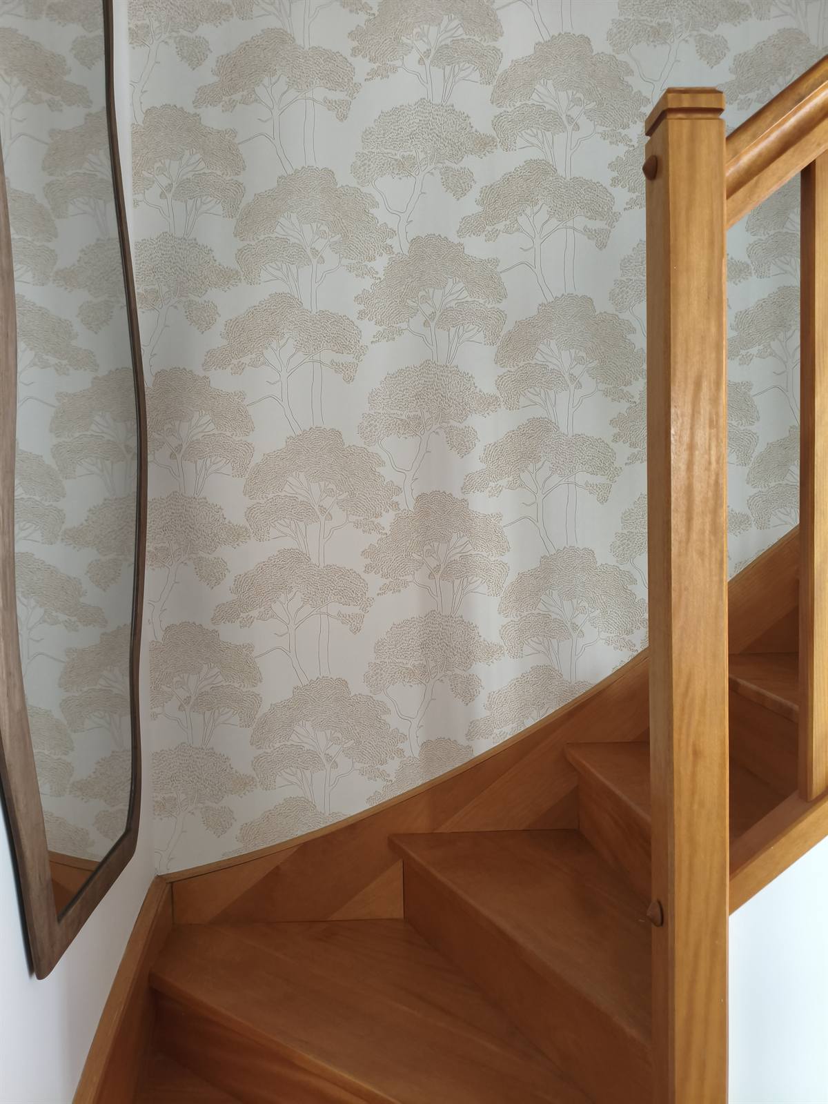 Papier peint végétal le long de l'escalier en bois, miroir aux formes organiques