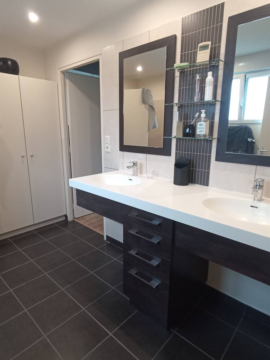 Avant : double vasque blanche sur meuble brun foncé, carrelage anthracite et placards blancs