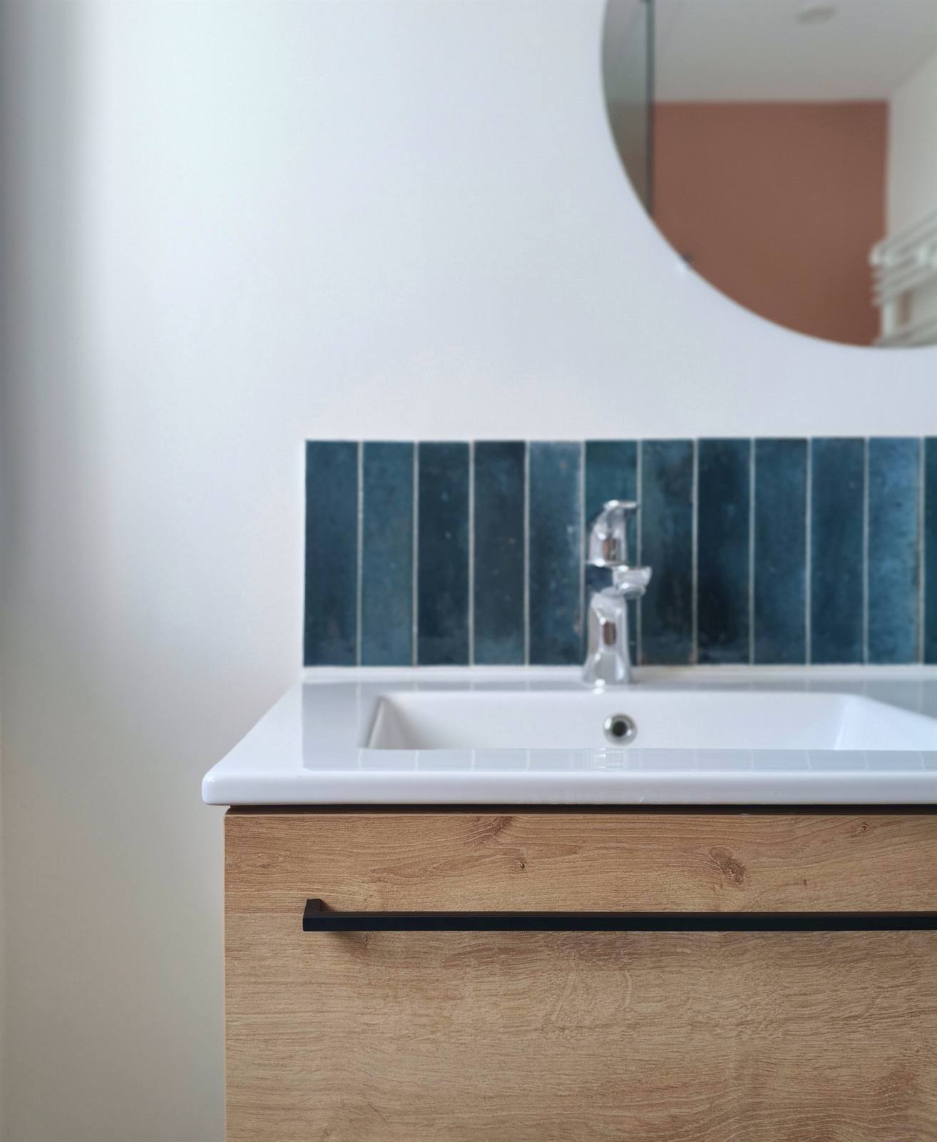 Détail de la vasque, de la robinetterie chromée et du zellige bleu canard