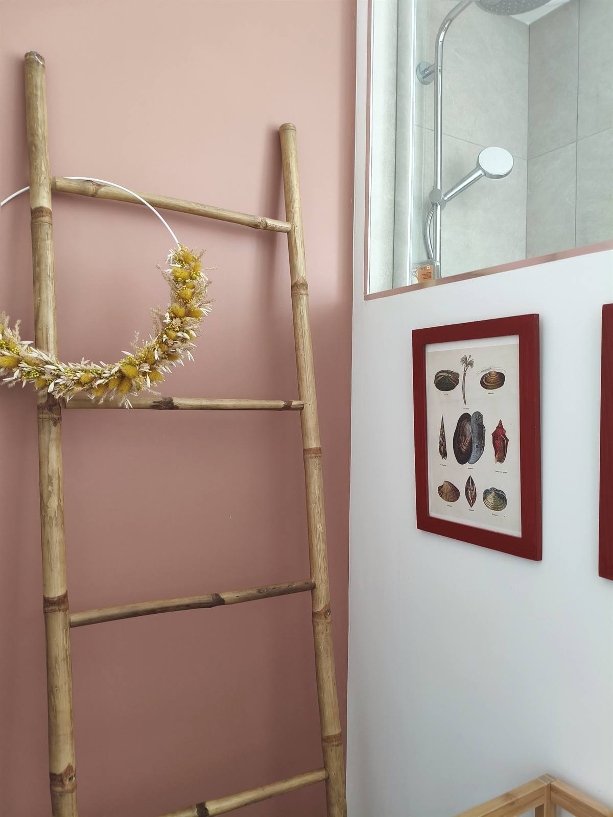 Échelle décorative en bambou contre le mur rose poudré de la salle de bains