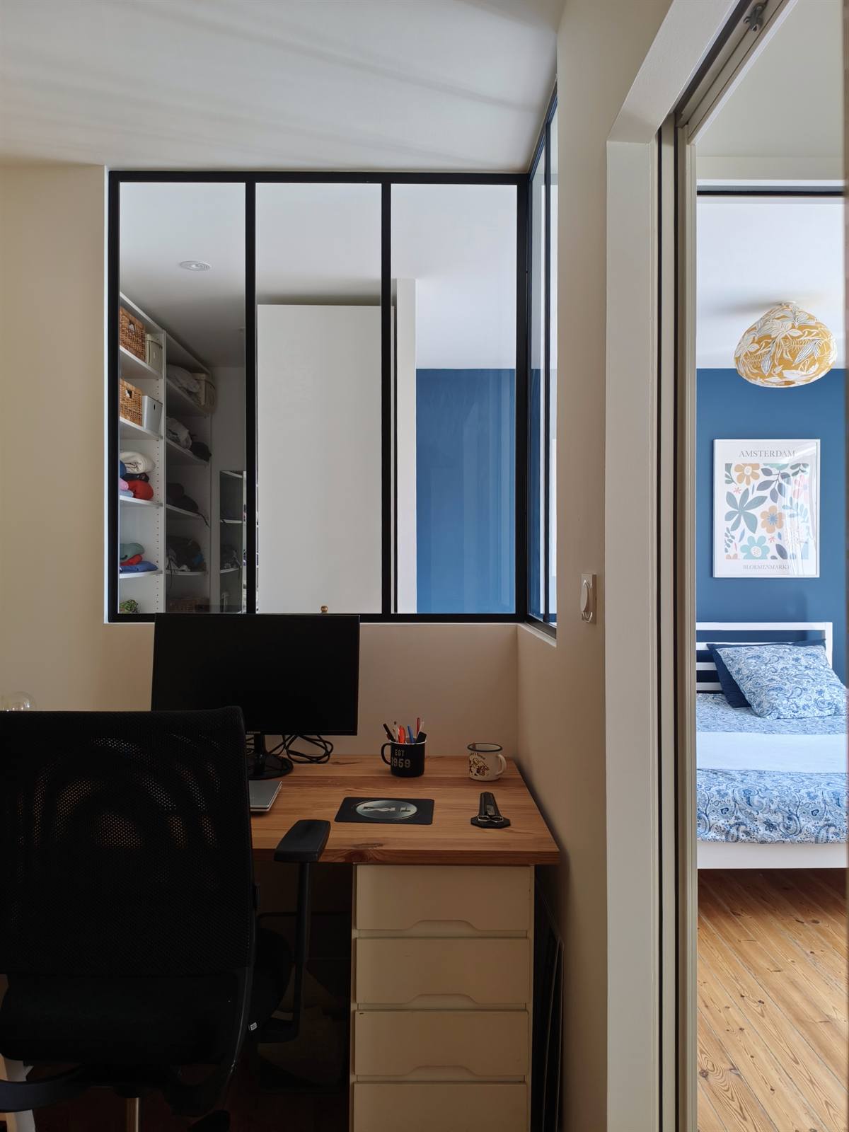 Bureau aménagé derrière la verrière, avec vue sur la chambre bleue