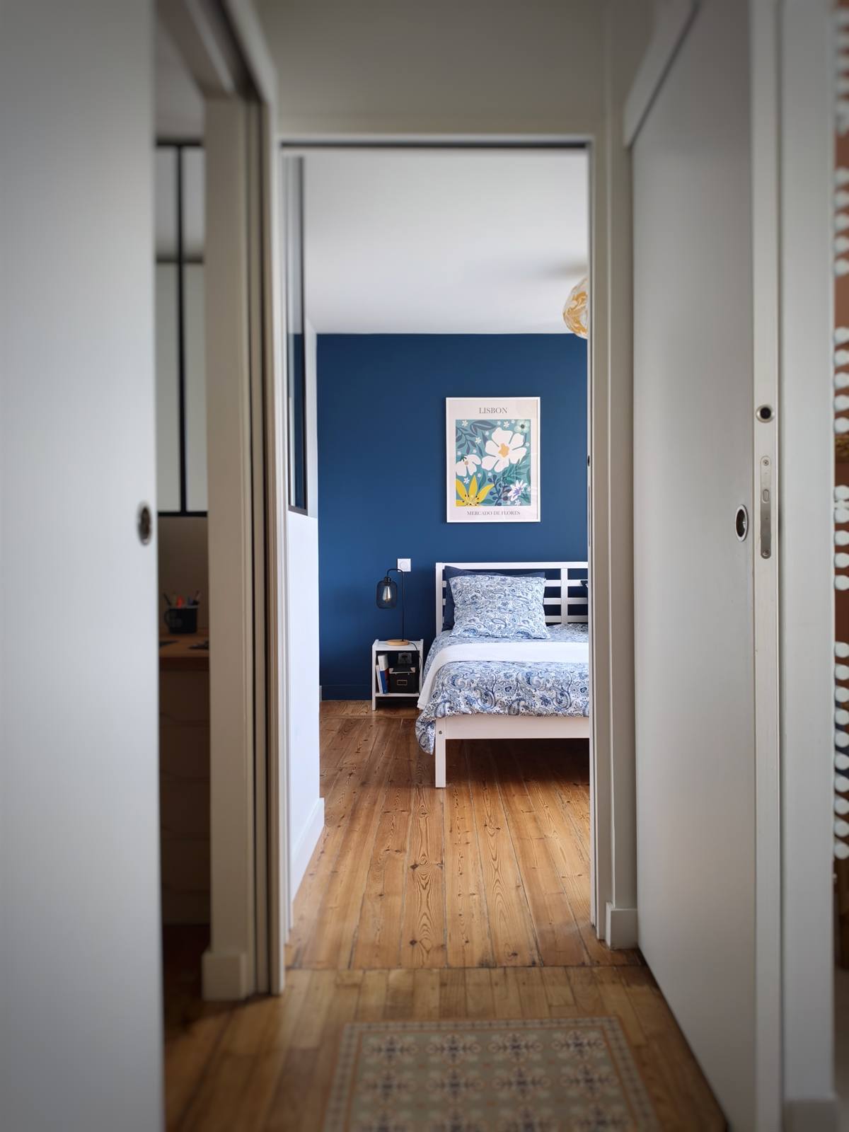 La chambre bleue vue depuis le couloir, porte coulissante ouverte