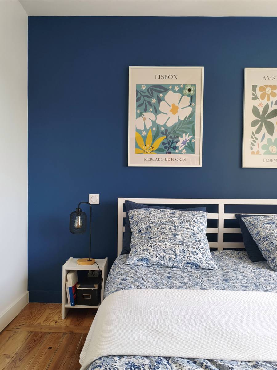 Après : mur bleu nuit, lit double et affiches botaniques