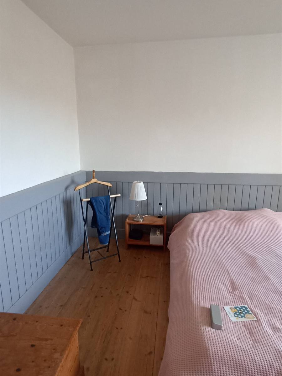 Avant : chambre au lambris gris à mi-hauteur et lit simple