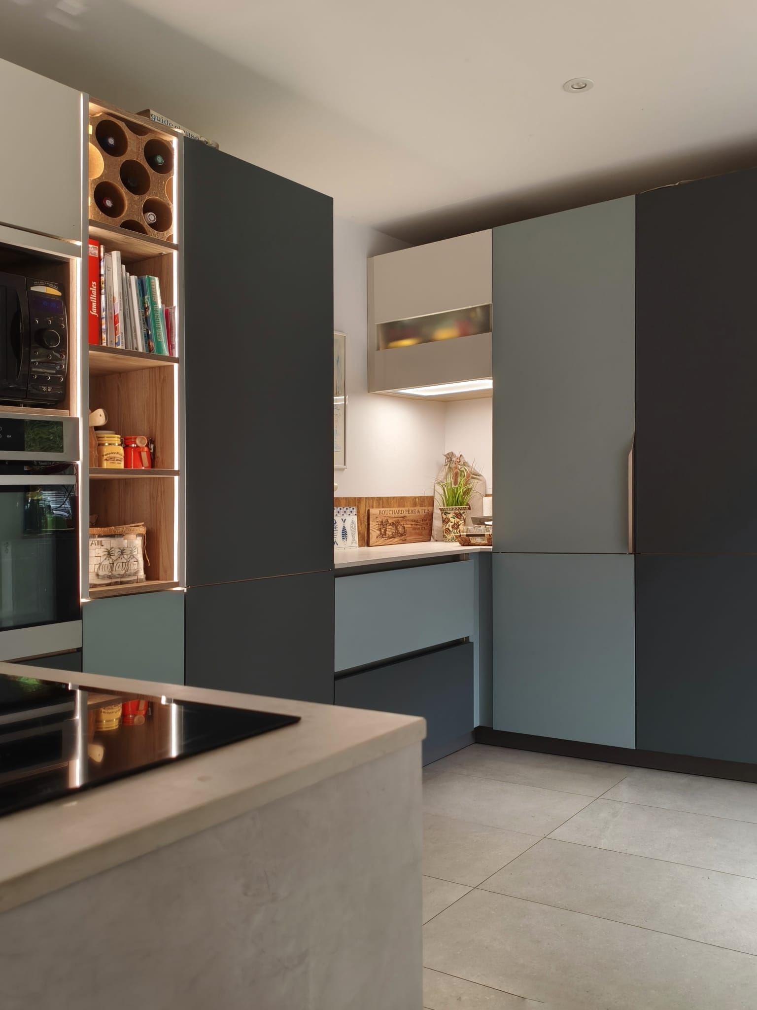 Îlot avec plaque de cuisson devant les colonnes bicolores et la niche à livres