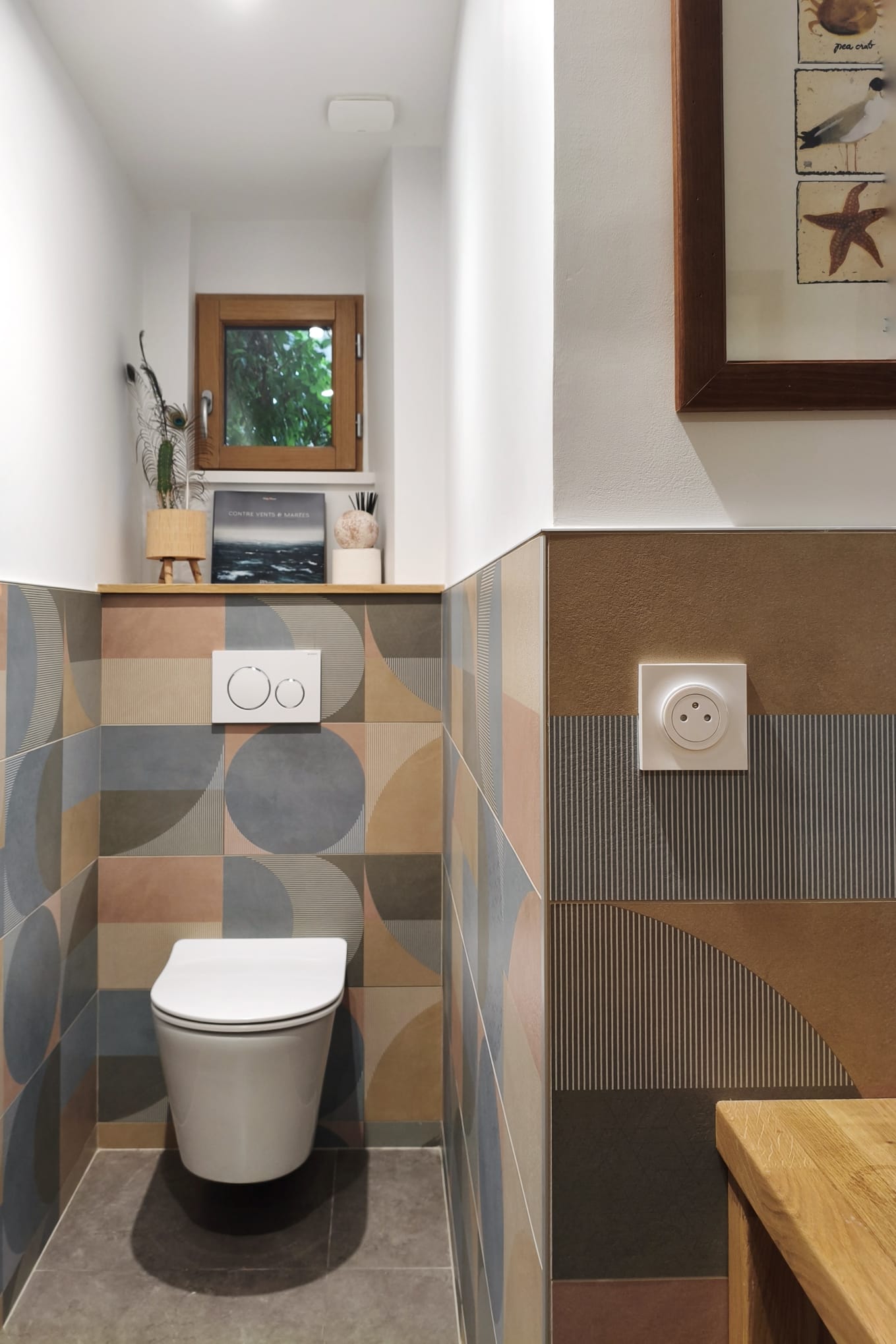 Toilettes avec WC suspendu et faïence colorée à motifs géométriques