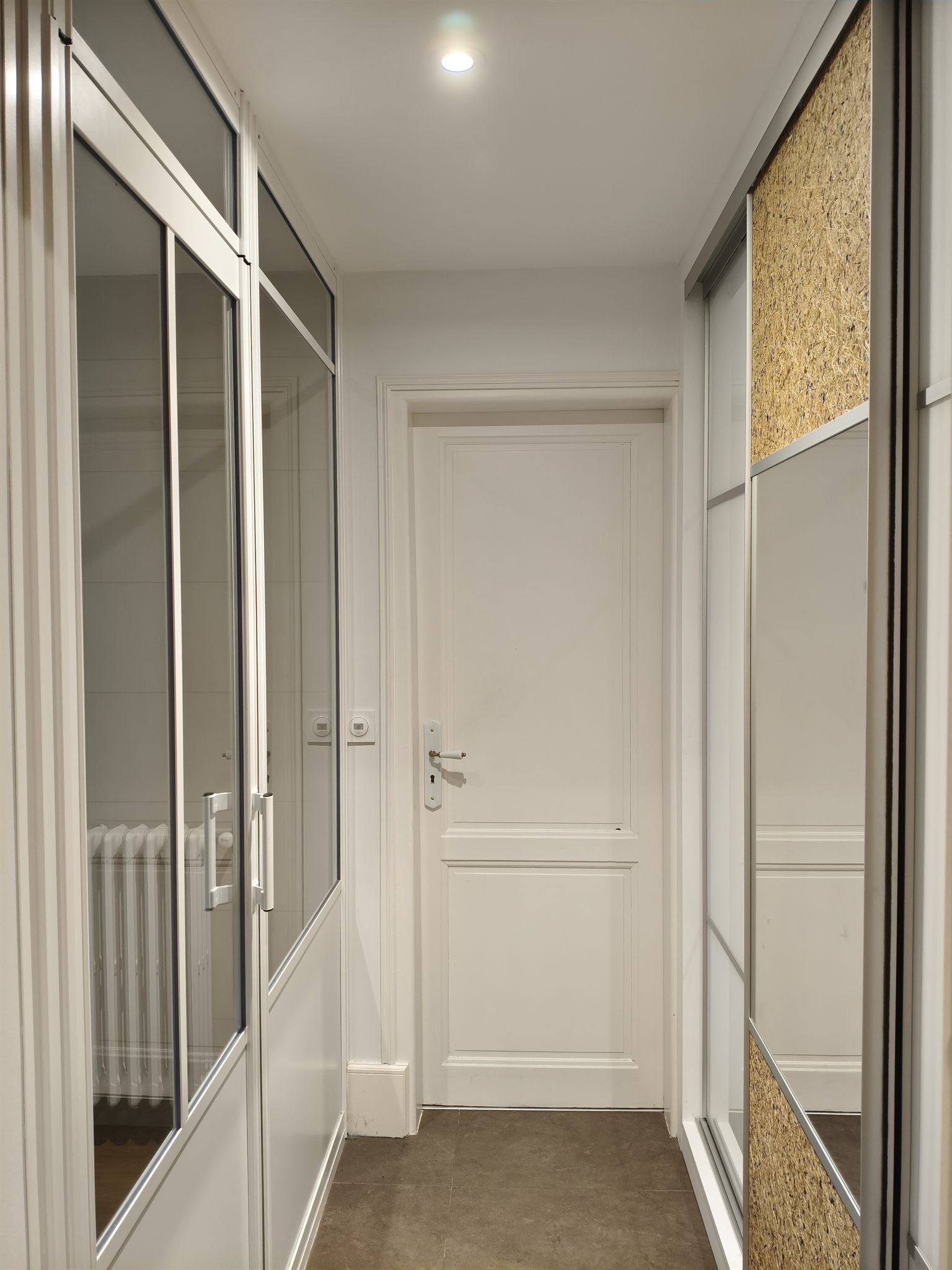 Dressing en couloir : cloison verrière blanche à gauche, placard coulissant à droite