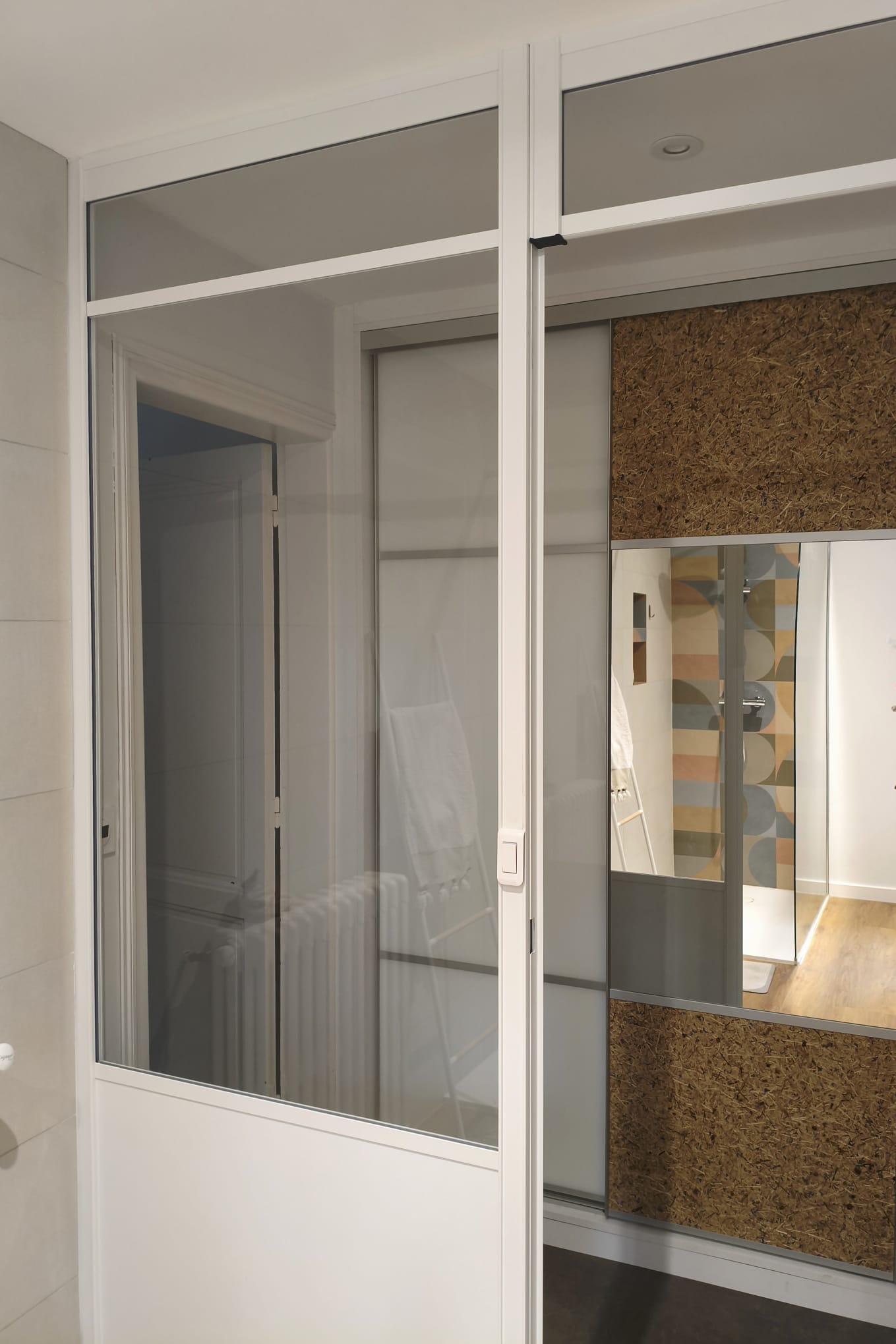 Cloison verrière blanche entre le dressing et la salle de bains