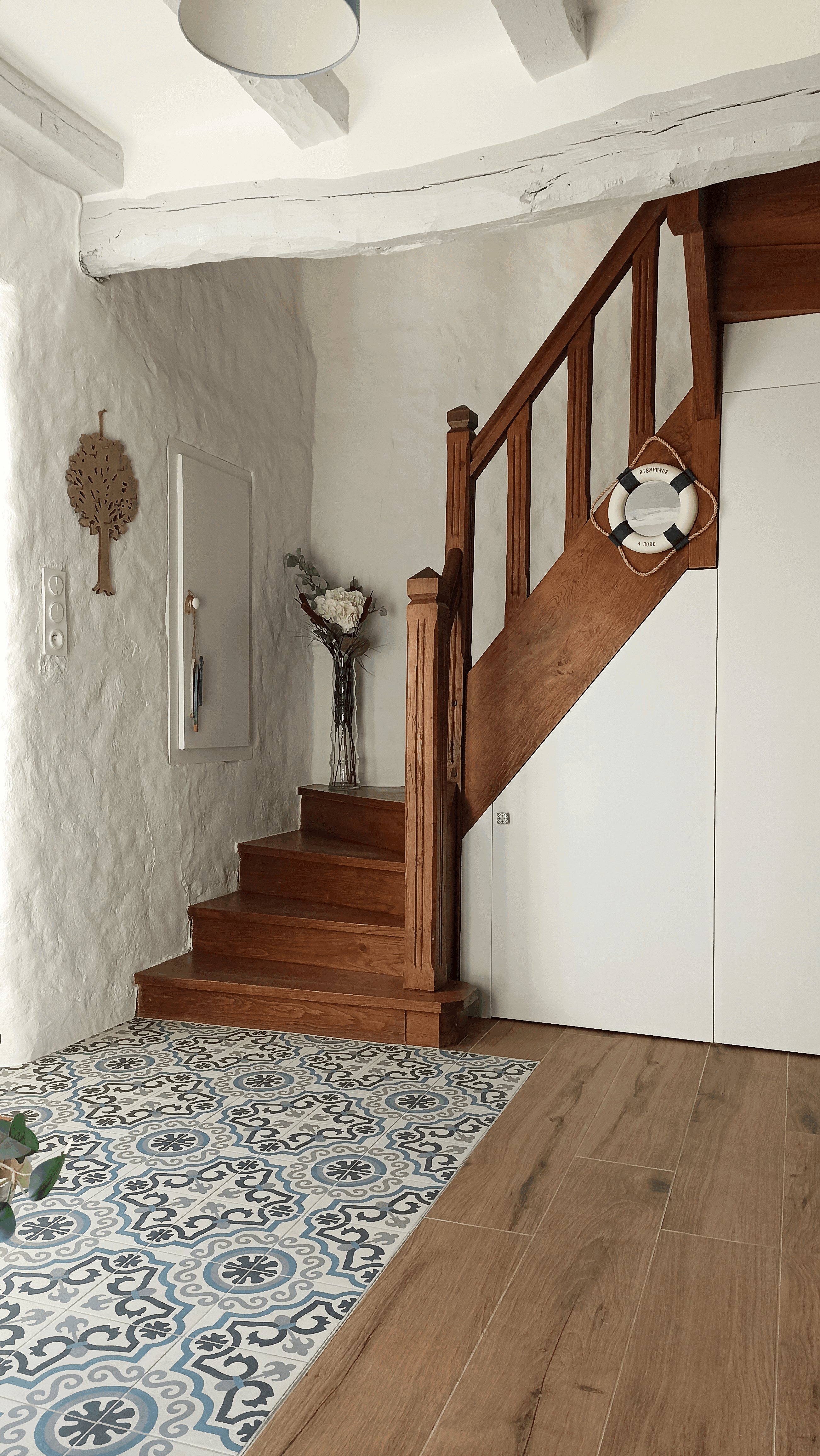 Escalier en bois de l'entrée, sol en carreaux de ciment et bouée décorative