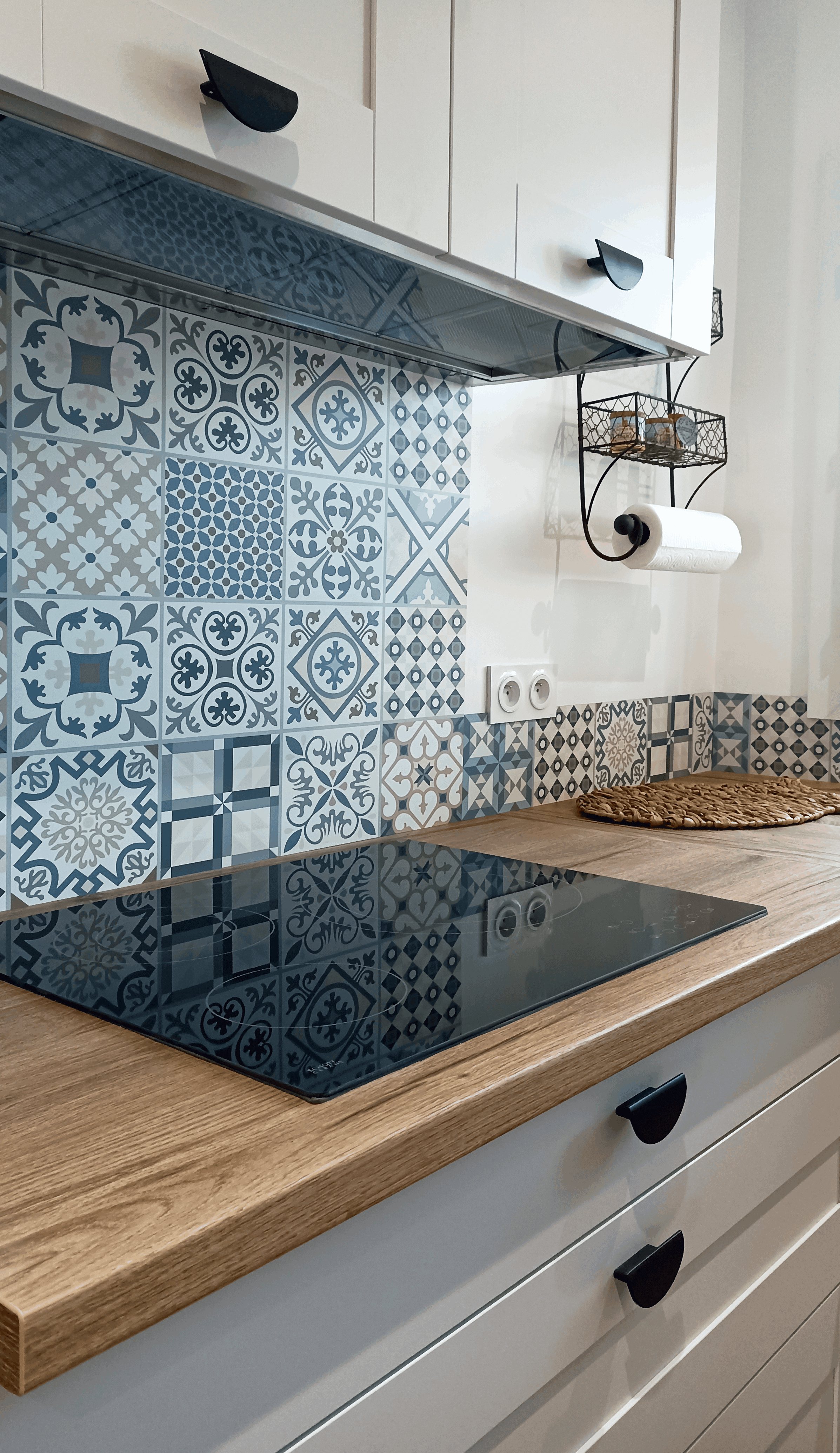 Détail de la crédence en carreaux de ciment bleus, plaque induction et poignées noires