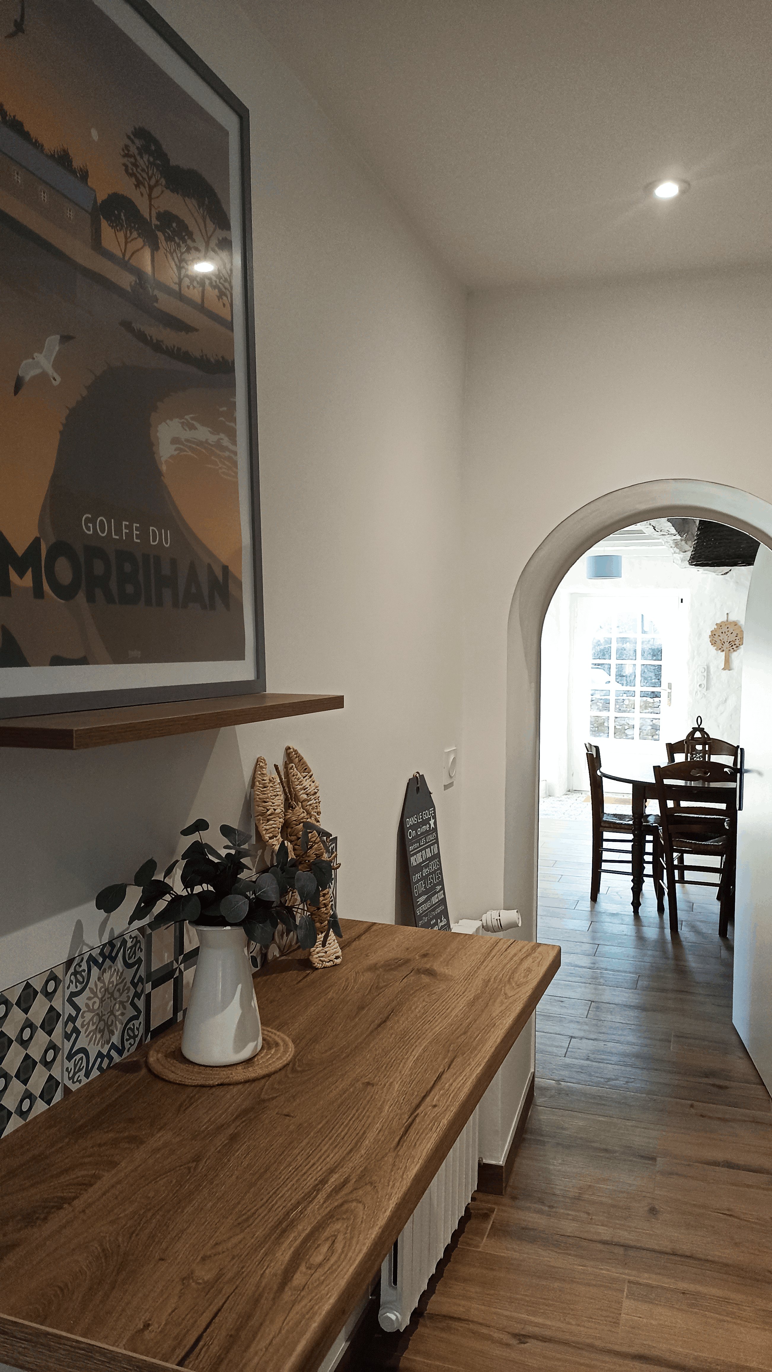 Entrée séparée de la pièce de vie : affiche du Golfe du Morbihan et tablette en bois