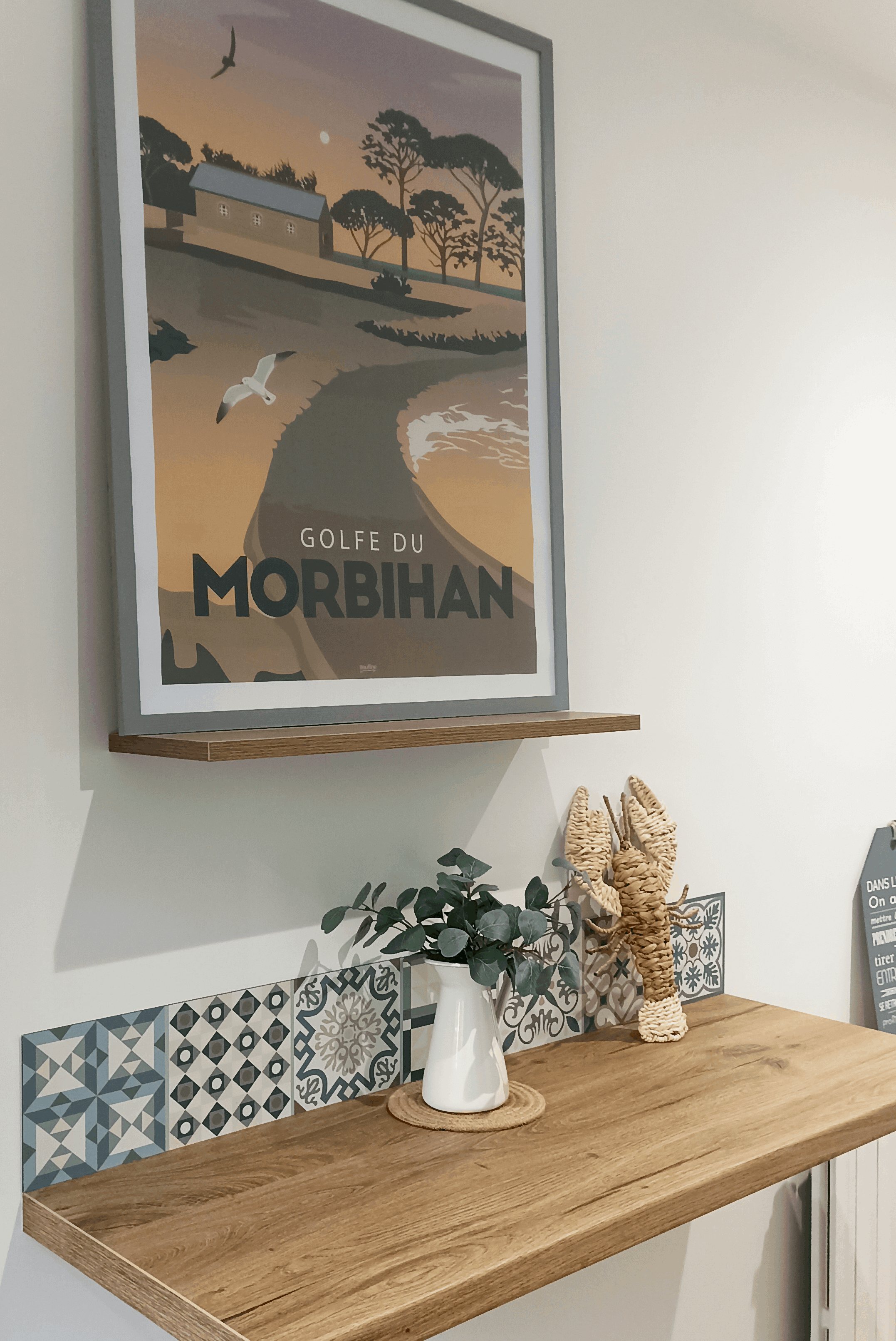 Tablette en bois et frise de carreaux décoratifs sous l'affiche encadrée